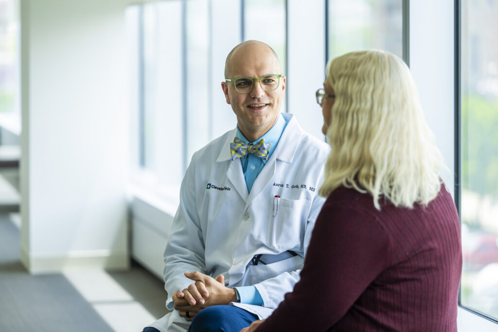 Photo of Dr. Gerds speaking to a patient while wearing his signature bow tie